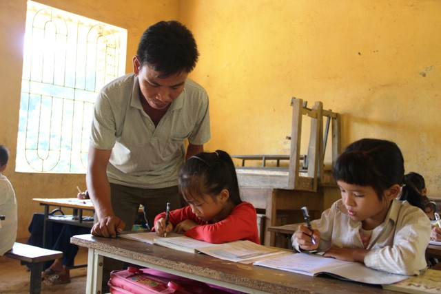 Thầy giáo Bùi Đình Sơn nắn nót từng nét chữ cho học trò. Ảnh: T.G