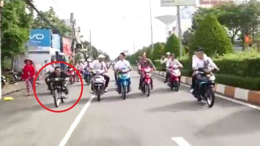 Nam thanh niên mặc đồ vest đen (khoanh tròn đỏ) chuẩn bị bốc đầu xe. Ảnh cắt từ clip