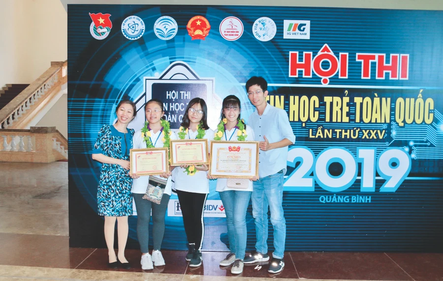 Đại diện nhóm em Tăng Thanh Hà, Lương Bảo Ngọc và Nguyễn Trương Mai Phương, cùng với thầy giáo hướng dẫn và cô hiệu trưởng vinh dự khi nhận giải Nhì tại Hội thi Tin học trẻ toàn quốc lần thứ 25 năm 2019 tại Quảng Bình. Ảnh: NVCC.