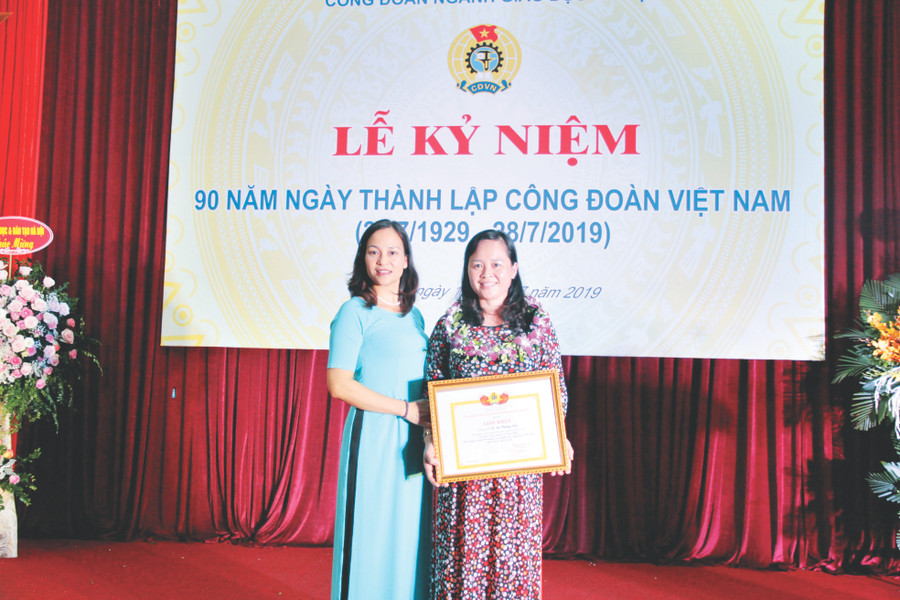 Đồng nghiệp chúc mừng cô Lê Thị Phương Lan (bên phải) nhận Giấy khen của Công đoàn ngành GD Hà Nội