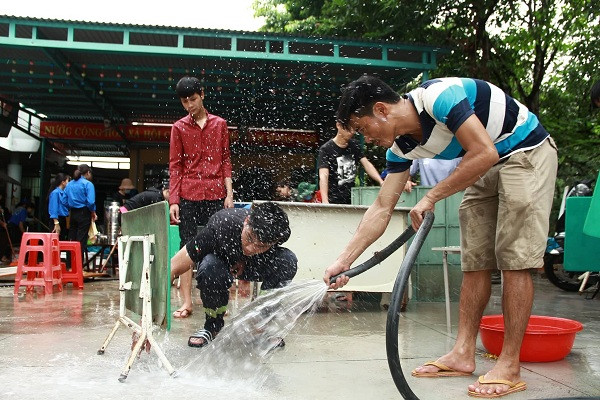 Lực lượng PCCC và tình nguyện viên giúp dọn dẹp trường học. Ảnh: Trúc Hân