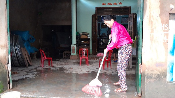 Bà Kĩ dọn dẹp nhà cửa sau lũ. Ảnh: Trúc Hân