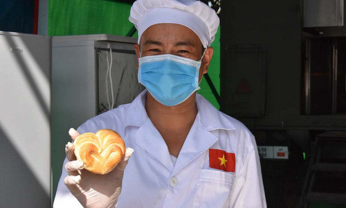 Thành viên đội Việt Nam với một chiếc bánh mì kem bơ tạo hình trái tim. Ảnh:QĐND. Thành viên đội Việt Nam với một chiếc bánh mì kem bơ tạo hình trái tim. Ảnh: QĐND.