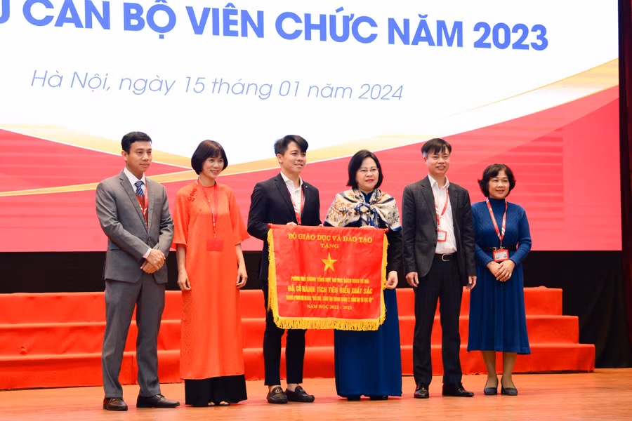 Thứ trưởng Ngô Thị Minh (thứ 3 từ phải sang) trao tặng Cờ thi đua của Bộ GD&amp;ĐT cho đại diện Văn phòng đại học thuộc ĐH Bách khoa Hà Nội.
