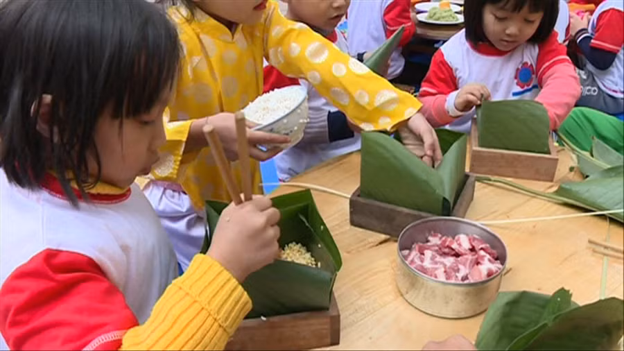 Bé trải nghiệm làm bánh chưng Tết.