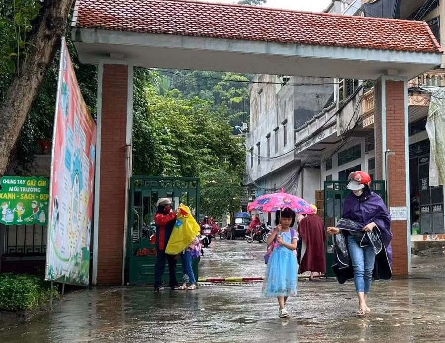 Nhiều phụ huynh "đội mưa" đưa con đến trường.