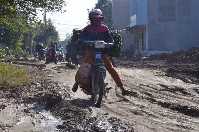 Mặt đường nhầy nhụa bùn đất gây khó khăn cho người tham gia giao thông.