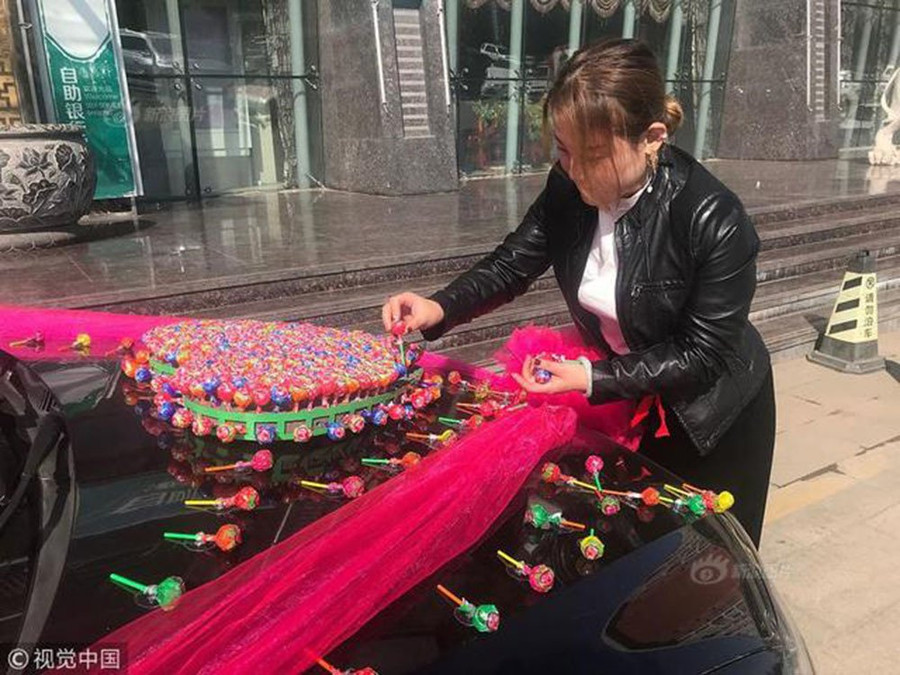 Chú rể Tiểu Cường nhờ người xếp 520 cây kẹo mút thành hình trái tim. Chú rể dùng 520 cây kẹo đi đón dâu, cưới vợ không mất một đồng sính lễ