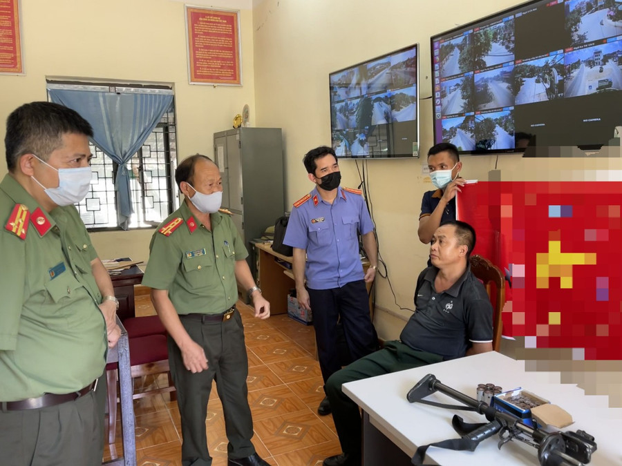 Đối tượng Lương Văn Định (áo đen) cùng tang vật thu giữ tại cơ quan Công an.