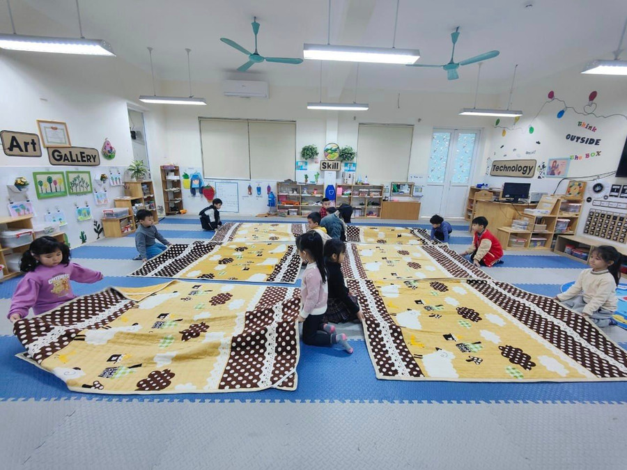 Trẻ cùng nhau trải chăn, đệm ấm trước khi đi ngủ tại Trường Mầm non Ngô Thì Nhậm (Hà Đông, Hà Nội).