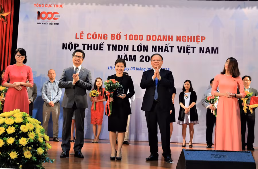 Ông Bùi Văn Nam - Tổng cục trưởng Tổng cục Thuế và ông Vũ Tiến Lộc - Chủ tịch Phòng thương mại và công nghiệp Việt nam (VCCI) trao hoa và kỷ niệm chương cho đại diện Nestlé Việt Nam