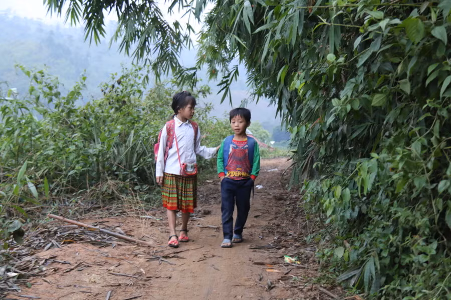 Các em học sinh với hành trang là gạo, rau... trên vai để mang ra trường tự lo cho bản thân trong những ngày đến lớp. 