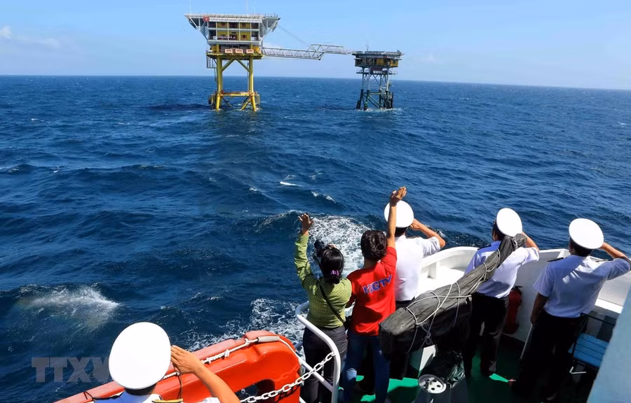 Các cán bộ chiến sĩ Vùng 2 Hải quân cùng các nhà báo, phóng viên trên tàu Trường Sa 19 vẫy chào cán bộ chiến sĩ trên Nhà giàn Dk1/15 (Phúc Nguyên) - Bãi cạn Tư Chính. (Ảnh minh họa: Thành Đạt/TTXVN)