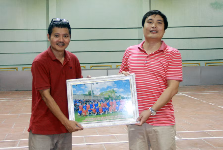 Thầy Triệu Trung Kiên trao ảnh kỷ niệm của hai đội bóng cho nhà báo Nguyễn Đức Tuân