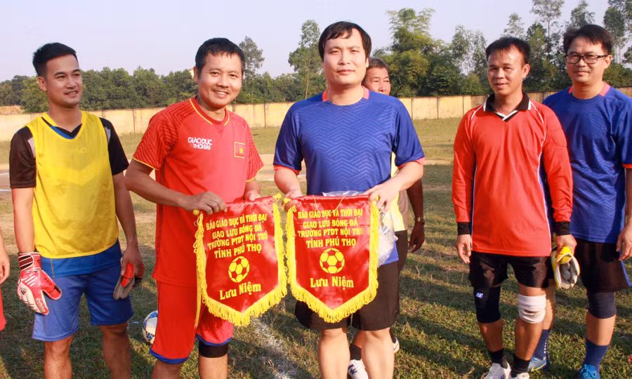 Nhà báo Nguyễn Đức Tuân và thầy Triệu Trung Kiên trao đổi cờ lưu niệm giữa hai đơn vị