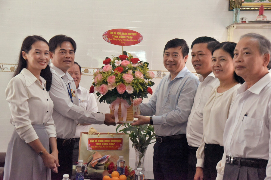 Nhà giáo Ưu tú Văng Công Sâu nhận hoa chúc mừng từ lãnh đạo tỉnh.