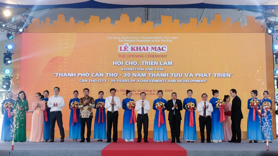 Đại biểu thực hiện nghi thức cắt băng khai mạc Hội chợ, triển lãm “Thành phố Cần Thơ - 20 năm thành tựu và phát triển”.