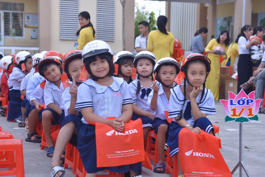 Các em học sinh lớp 1, Trường TH Thị trấn Lấp Vò 1 phấn khởi khi được nhận mũ bảo hiểm