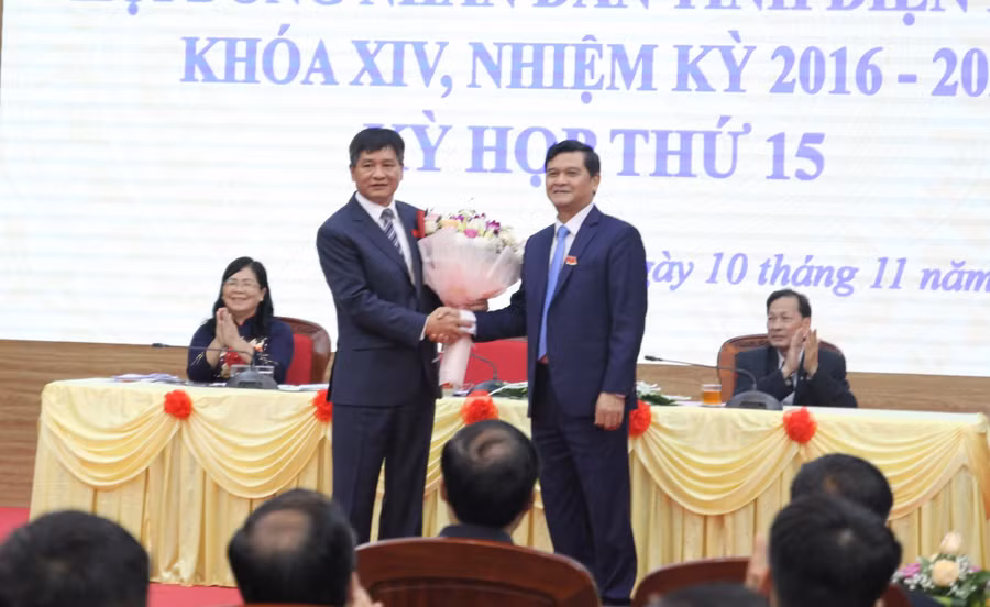 Ông Lê Thành Đô (bên trái) nhận hoa chúc mừng tại kỳ họp