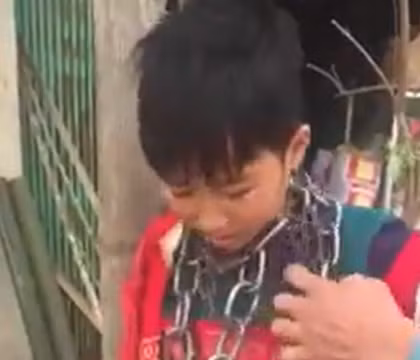 Bé L.B.N bị chú ruột xích và khóa lại do thường xuyên trộm cắp tài sản của gia đình để bán lấy tiền chơi game. Ảnh cắt từ clip