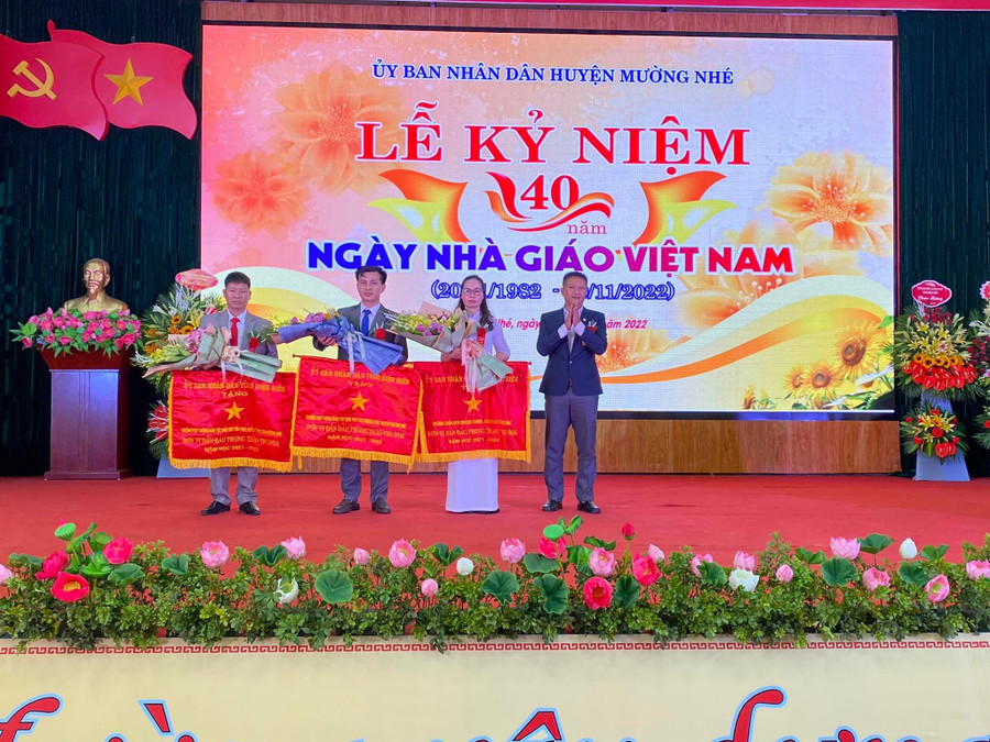 Thừa ủy quyền của Chủ tịch UBND tỉnh, ông Nguyễn Văn Hưng - Chủ tịch UBND huyện Mường Nhé trao cờ thi đua cho các tập thể lao động xuất sắc