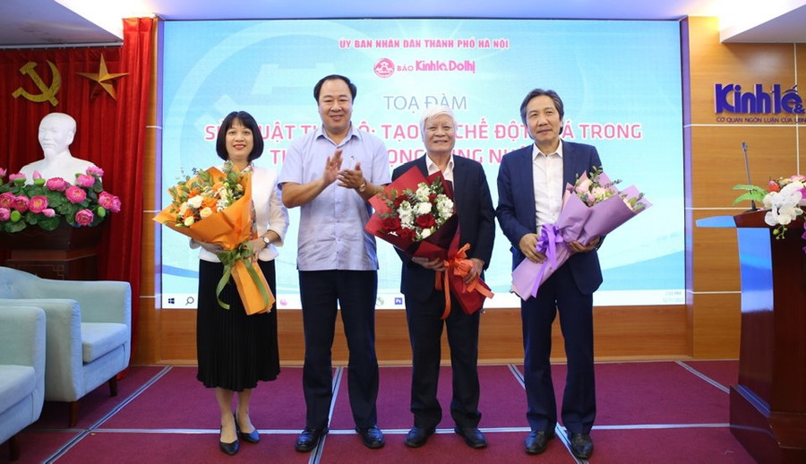 Phó Tổng biên tập Báo Kinh tế &amp; Đô thị Nguyễn Xuân Khánh tặng hoa các vị diễn giả tham dự toạ đàm