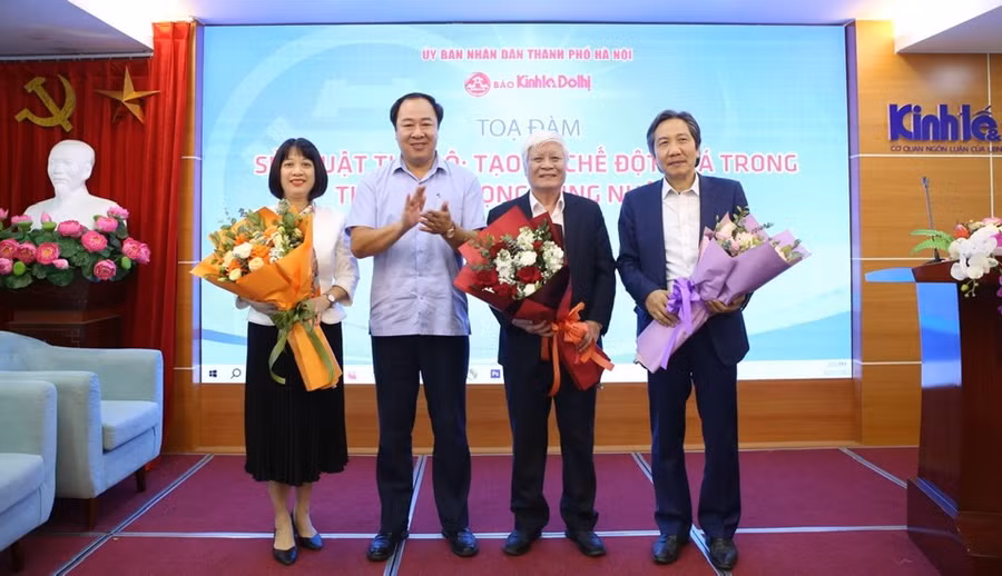 Phó Tổng biên tập Báo Kinh tế &amp; Đô thị Nguyễn Xuân Khánh tặng hoa các vị diễn giả tham dự toạ đàm