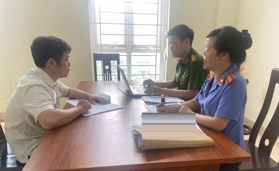 Cơ quan chức năng làm việc với Trần Anh Tuấn. Ảnh: CANA.