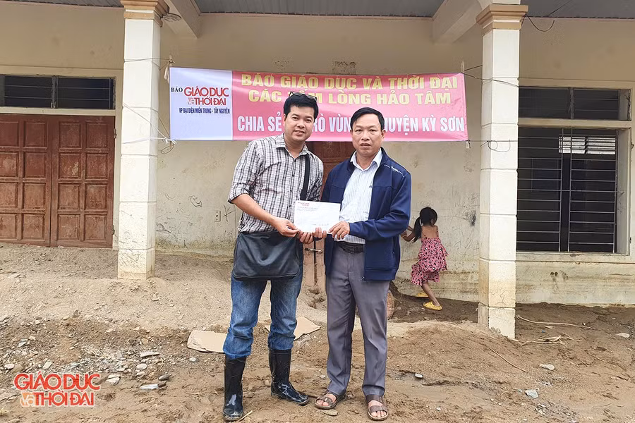 Nhà báo Nguyễn Văn Dũng - Trưởng đại diện Văn phòng Báo Giáo dục và Thời đại khu vực miền Trung - Tây Nguyên trao số tiền 10 triệu đồng cho lãnh đạo Trường PTDTBT Tiểu học và THCS Tà Cạ.