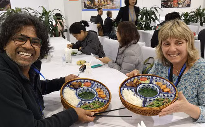 Các phóng viên cuốc tế vui vẻ thưởng thức các món ăn truyền thống của Việt Nam.