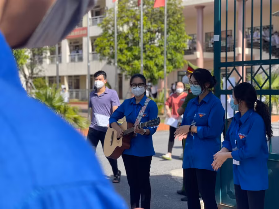 Tình nguyện viên tại điểm Trường THPT Chuyên Hà Tĩnh đánh đàn chúc mừng kết thúc kỳ thi đợt 1.