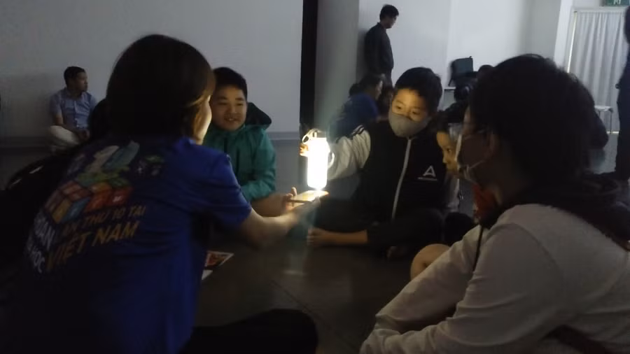 Học sinh hào hứng với thí nghiệm quan sát màu xanh da trời qua ánh sáng chiếu vào bình nước thủy tinh. Ảnh: Bình Thanh.