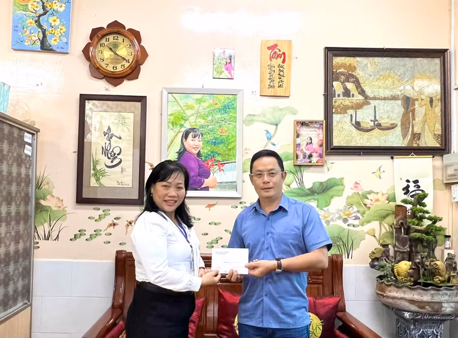 Cô Lê Thụy Phương Linh, Hiệu trưởng Trường Tiểu học Lê Văn Thọ, Quận Gò Vấp trao 30 suất học bổng cho đại diện của Báo Giáo dục và Thời đại.