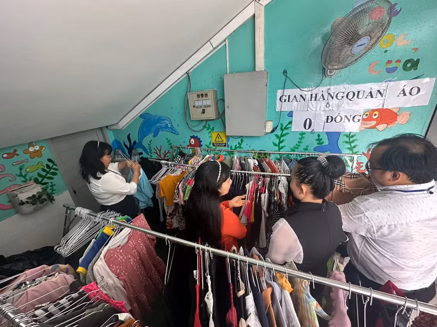 Thầy cô giáo lựa chọn quần áo tại gian hàng quần áo 0 đồng do Công đoàn trường tổ chức.