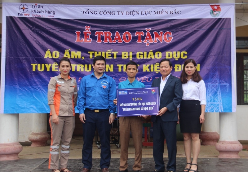 Ông Nguyễn Phúc Phong , Giám đốc Công ty điện lực Hà Tĩnh (bên phải thứ 2) trao quà cho Trường tiểu học Hương Liên.