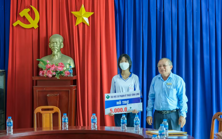 PGS. TS Cao Hùng Phi, Hiệu trưởng Trường ĐH Sư phạm Kỹ thuật Vĩnh Long trao học bổng cho học sinh.