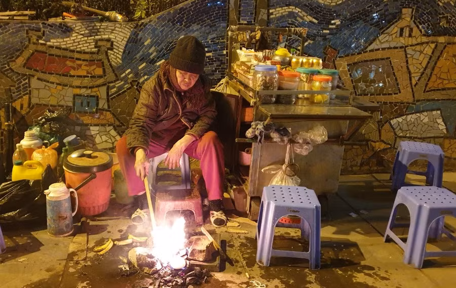 Một cụ bà khoảng ngoài 70 tuổi, bán trà gần dốc lên cầu Chương Dương (phía Nam) dù đã khuya nhưng vẫn kiên nhẫn bên đống lửa hy vọng có khách.