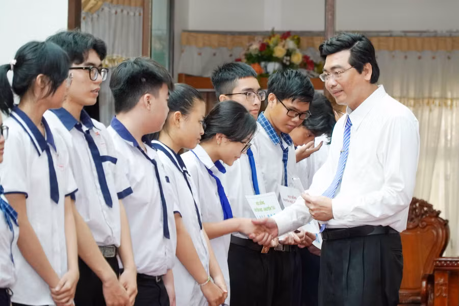 Ông Trần Thanh Bình, Giám đốc Sở GD&amp;ĐT trao tặng học bổng cho các em học sinh.