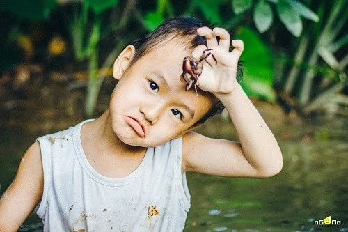 Trở về tuổi thơ qua bộ ảnh “Mò ốc” mộc mạc của cậu bé miền Tây