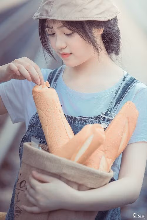 Được biết, bộ ảnh lấy bối cảnh tại Cửa khẩu quốc tế Lào Cai. Hình ảnh cô gái bên đường ray dễ thương và được dân mạng nhìn mặt đặt tên "hot girl bán bánh mì".