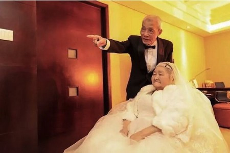 Cụ ông U90 thể hiện tình yêu với vợ trên tòa cao ốc ảnh 1 Cụ ông Qiao Dewei và vợ xuất hiện trong trang phục cưới vào dịp kỷ niệm 67 năm ngày cưới của 2 người