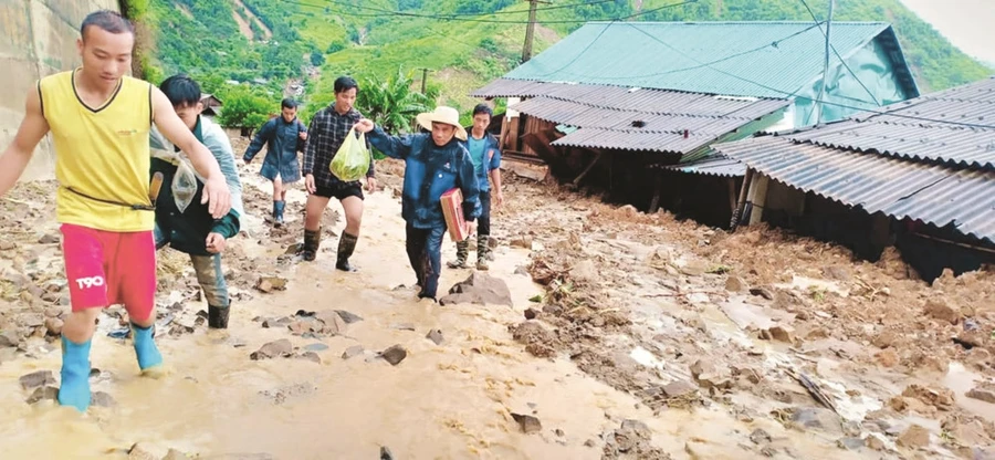 Các thầy cô Trường tiểu học Nhi Sơn và bà con tìm cách vào nhà lấy giấy tờ cho giáo viên