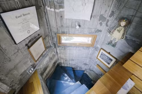 Cầu thang nhỏ xoắn ốc chỉ đủ một người bước. Trên tường được kiến trúc sư khéo léo trang trí bằng những bức tranh, bằng khen... xua đi cảm giác ảm đạm, đơn điệu của màubê tông. Các phòng trong nhàriêng lẻ, xếp chồng lên nhau mà không có cửa ngăn, phòng tắm cũng chỉ được ngăn cách bằng rèm cửa.