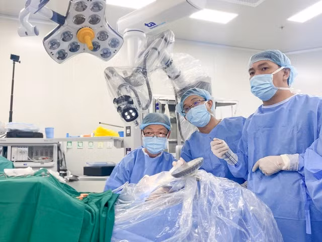 Bác sĩ Tấn Sĩ (người ngồi) và cộng sự trong ca mổ não tỉnh thức cho người bệnh bằng Robot Modus V Synaptive. (Ảnh: Nguyễn Trăm)