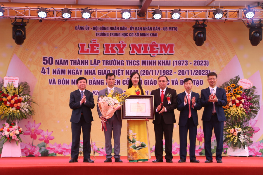 Ông Trần Văn Nghĩa (bìa trái) - Phó Bí thư thường trực Huyện ủy, Chủ tịch HĐND huyện Hoài Đức trao tặng Bằng khen của Bộ trưởng Bộ GD&amp;ĐT cho nhà trường.