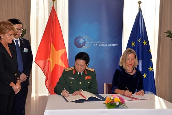 Đại tướng Ngô Xuân Lịch cùng bà Federica Mogherini ký Hiệp định FPA. Ảnh: Quân đội nhân dân