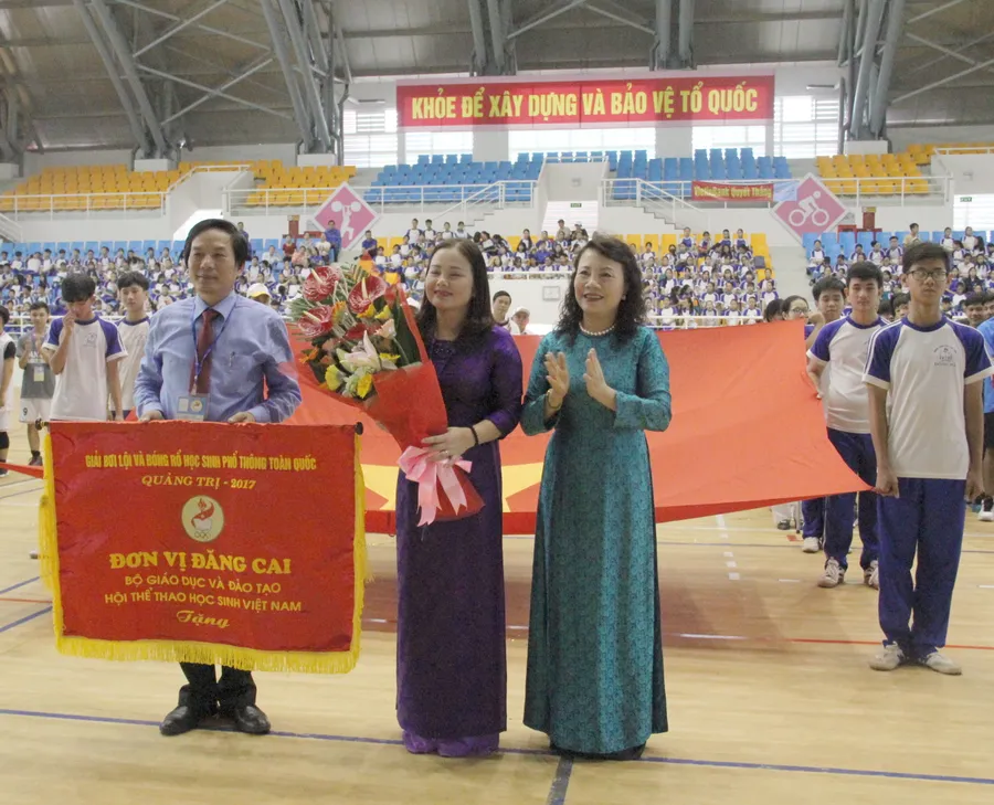 Thứ trưởng Nguyễn Thị Nghĩa tặng hoa và trao cờ cho ngành GD&ĐT tỉnh Quảng Trị - đơn vị đăng cai giải - trong lễ khai mạc giải.