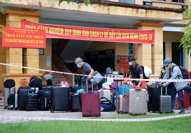 Công dân hoàn thành thời gian cách ly vận chuyển đồ đặc cá nhân để trở về địa phương. (Ảnh: Thanh Hải/TTXVN).