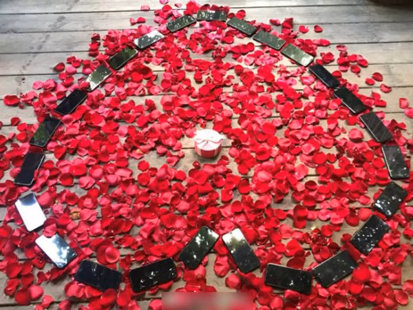 25 chiếc iPhone X xếp thành hình trái tim trên nền rải đầy hoa hồng