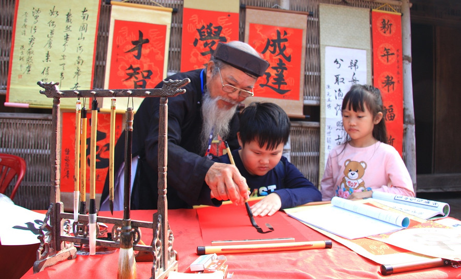 Thầy đồ Nguyễn Thiên Thuyết hướng dẫn các cháu nhỏ tập viết thư pháp. Thầy đồ Nguyễn Thiên Thuyết hướng dẫn các cháu nhỏ tập viết thư pháp.